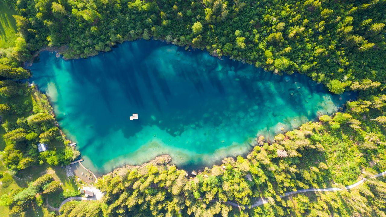 Blue-green forest lake, white raft