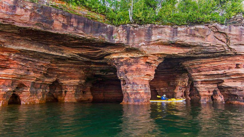 Kayakistes explorant les caves marines de grès rouge dans les Iles des Apôtres près de Bayfield, Wisconsin