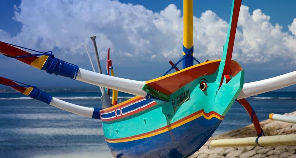 Traditional fishing craft drawn up on the sandy beach of Denpasar, Indonesia