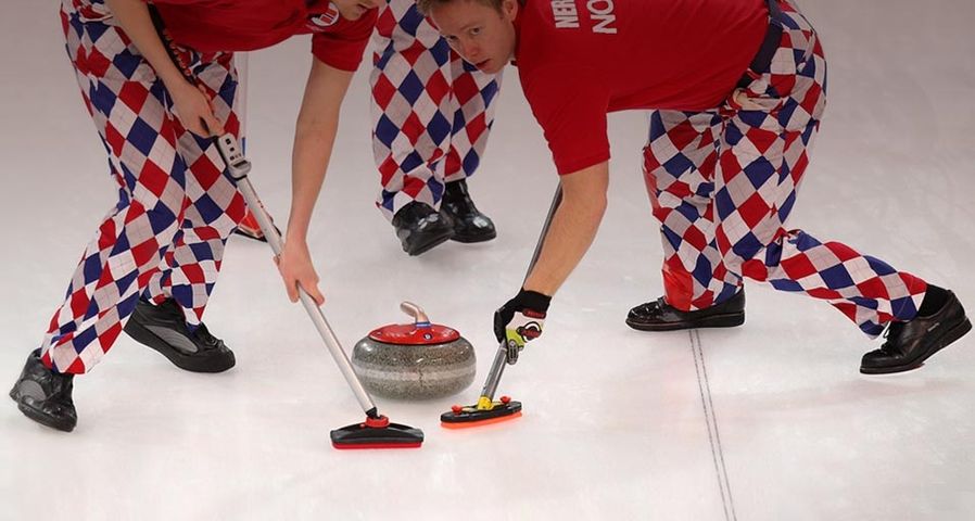 Haavard Vad Petersson and Torger Nergaard of Norway sweep a path for the stone during the Men's Curling at the Vancouver 2010 Winter Olympics on February 16, 2010