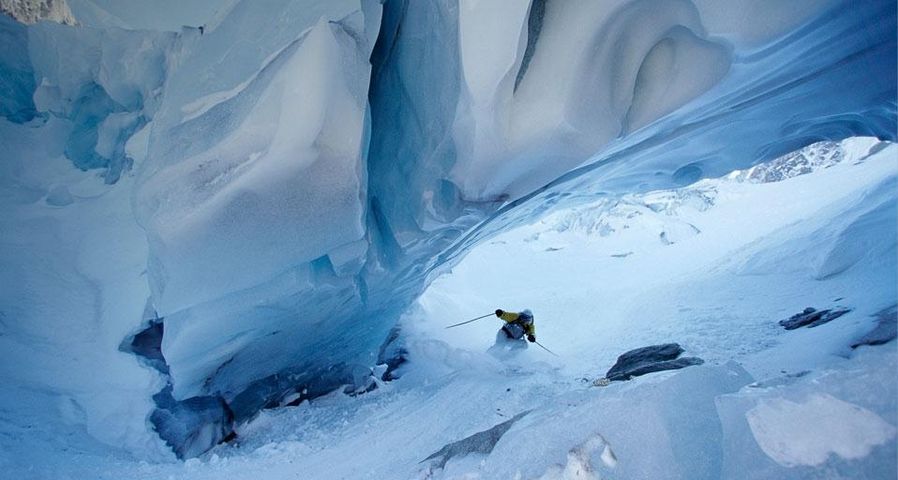 Skieur passant sous une arche de glace près de Chamonix, Haute-Savoie, Rhône-Alpes
