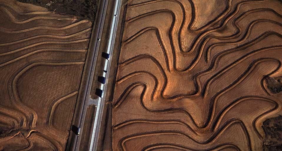 Highway 287 cuts through curving plowed fields near Carey, Texas