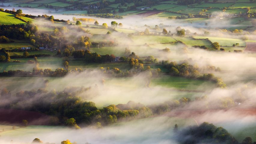 Mist blows over rolling countryside near Talybont-on-Usk in Brecon Beacons National Park, Wales 