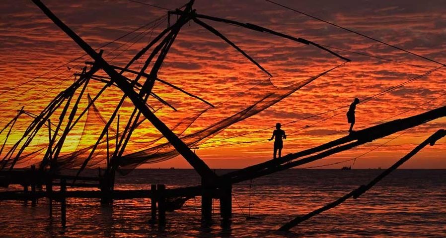 People fishing at sunset in Kerala, India
