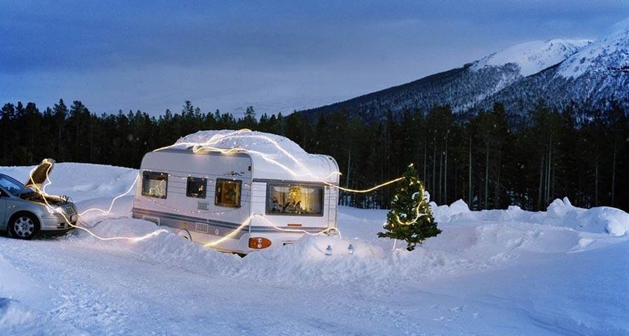 Eine Autobatterie speist die Weihnachtsbeleuchtung eines Wohnwagens und eines Weihnachtsbaums in Måndalen, Norwegen