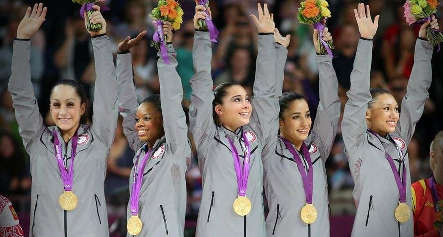 Jordyn Wieber, Gabrielle Douglas, McKayla Maroney, Alexandra Raisman, and Kyla Ross of the United States celebrate on the podium after winning the gold medal in the artistic gymnastics women's team final in London, England