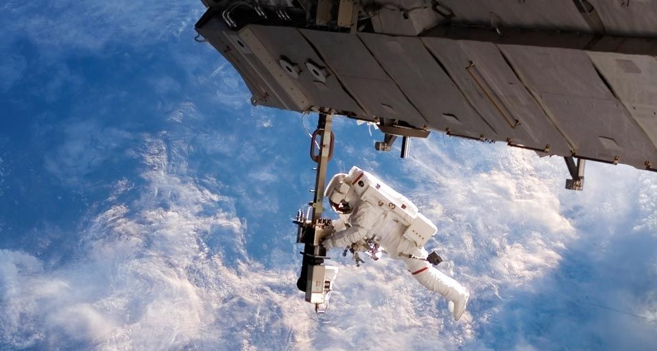 An astronaut performing a space walk outside of the International Space Station