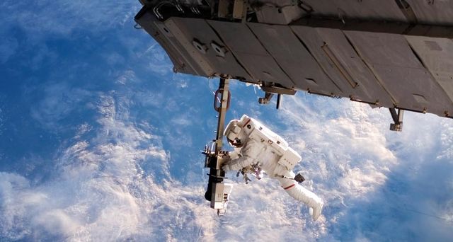 An astronaut performing a space walk outside of the International Space Station