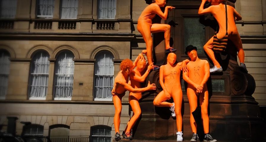 Street performers climbing statue for the Edinburgh Festival, Edinburgh, Scotland