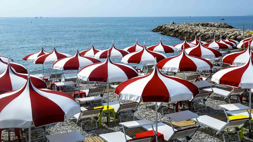 Parasols rouges et blancs sur une plage de Cagnes-sur-Mer, Provence-Alpes-Côte d'Azur, France 
