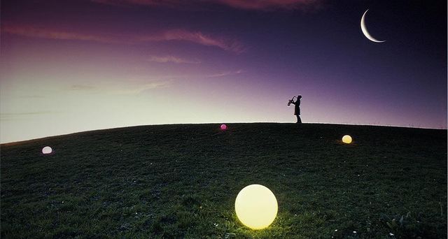 Silhouette d’un homme jouant du saxophone sous la lune