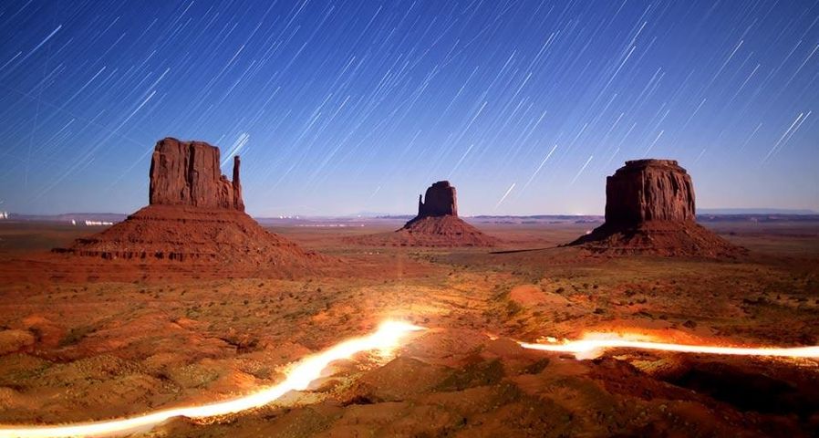 Still image of time-lapsed night sky and lights in Monument Valley Navajo Tribal Park, Utah, U.S.A.