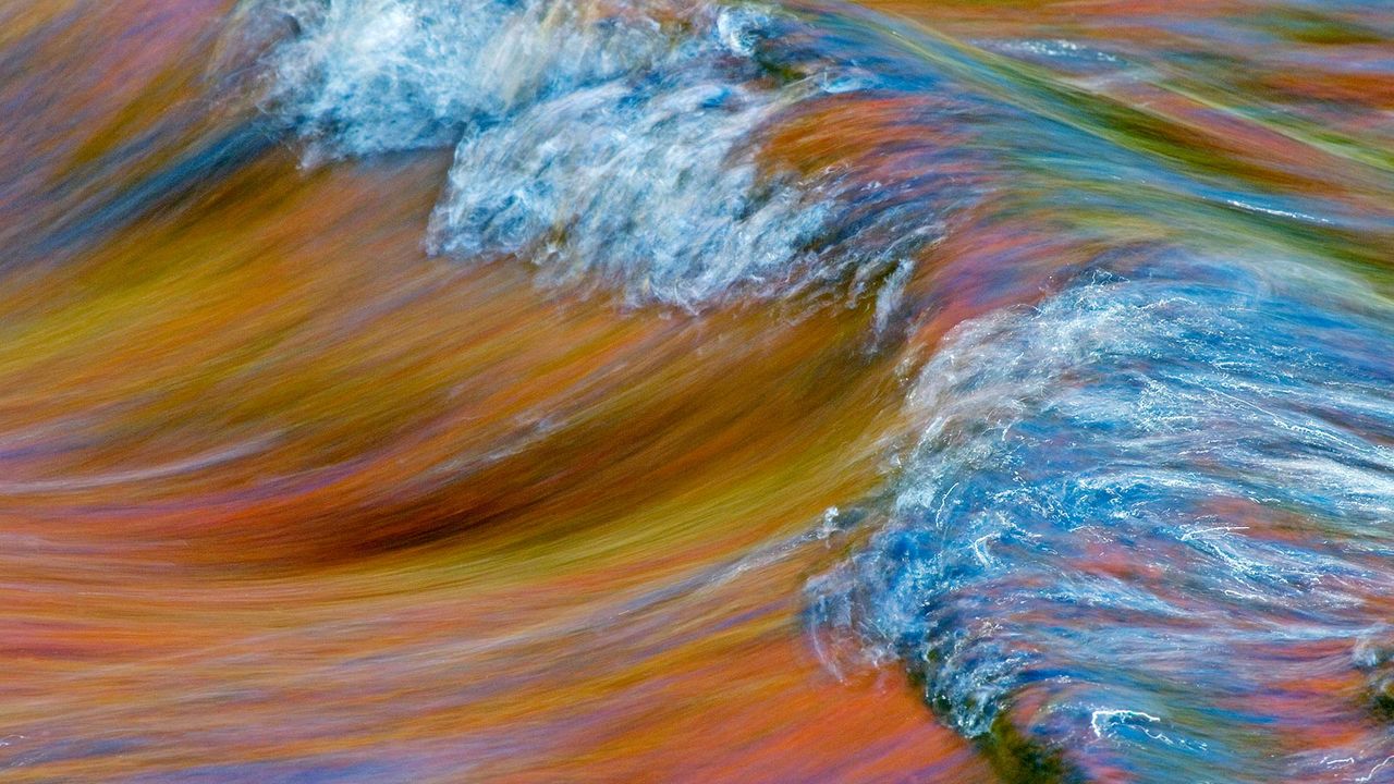 Autumn foliage colours reflect on rapids in Rivière-du-Nord, Quebec