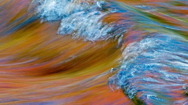 Autumn foliage colours reflect on rapids in Rivière-du-Nord, Quebec