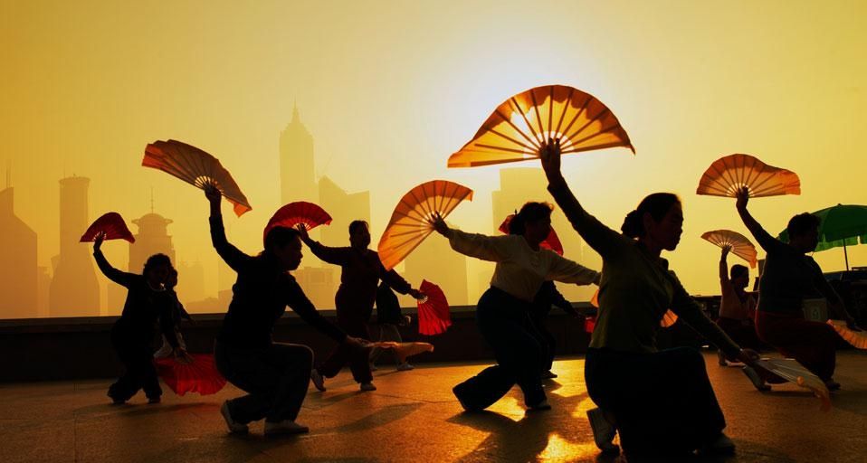 Women fan dancing on the Bund overlooking the Pudong district in Shanghai, China