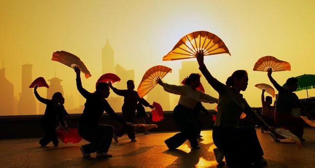 Women fan dancing on the Bund overlooking the Pudong district in Shanghai, China