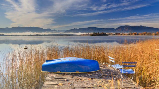 Blaues Ruderboot am herbstlichen Staffelsee, Bayern, Deutschland