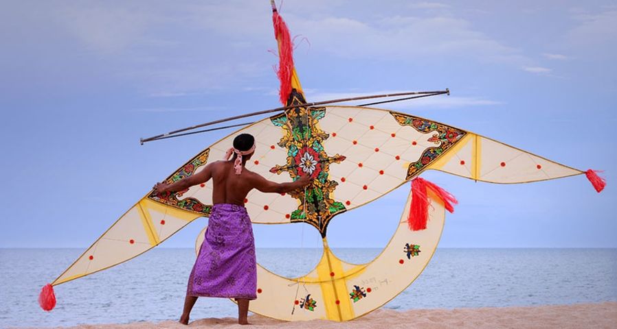 A Malaysian man holds a traditional handmade kite