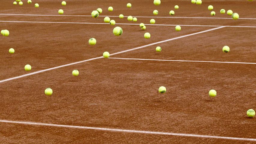 Balles de tennis oubliées sur un terrain en terre battue de Roland Garros 