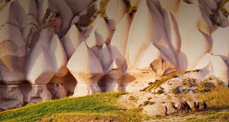 Eroded rock formations and camels in Uchisar, Cappadocia, Turkey