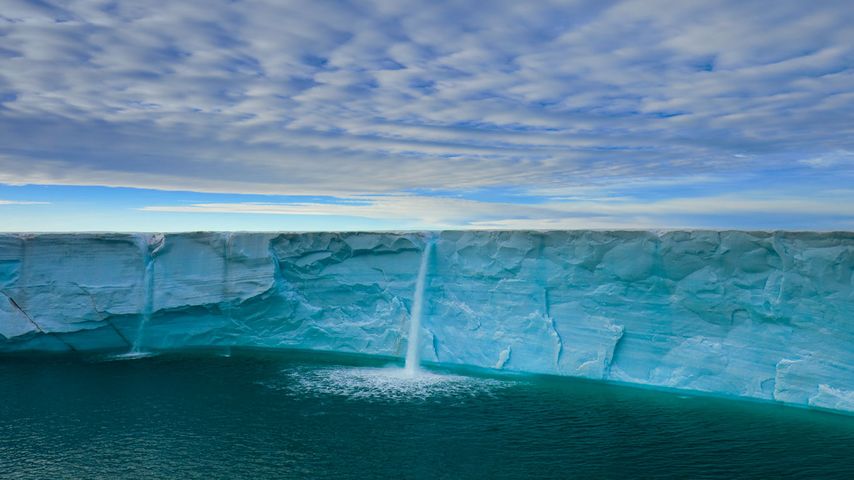 Schmelzwasser ergießt sich als Wasserfall von einer Eiskappe, Spitzbergen, Norwegen