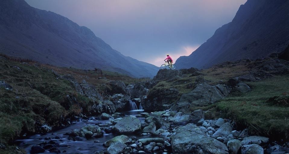 Cyclist on mountain bike, Honister Pass, The Lake District, Cumbria, England