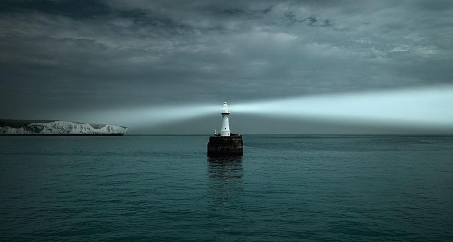 Lighthouse shining on White Cliffs of Dover and the English Channel