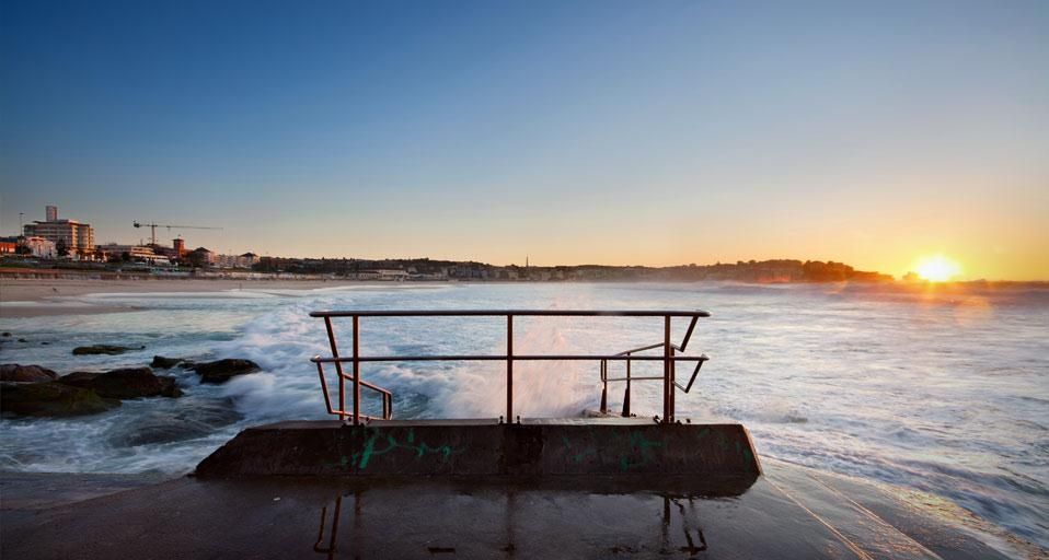 Sunrise on Bondi Beach in Sydney, Australia with a handrail in foreground