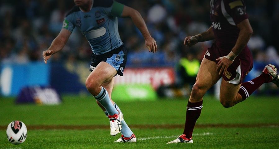 Two players chase the ball during a game of the NRL State of Origin series at ANZ Stadium in Sydney, Australia in 2009