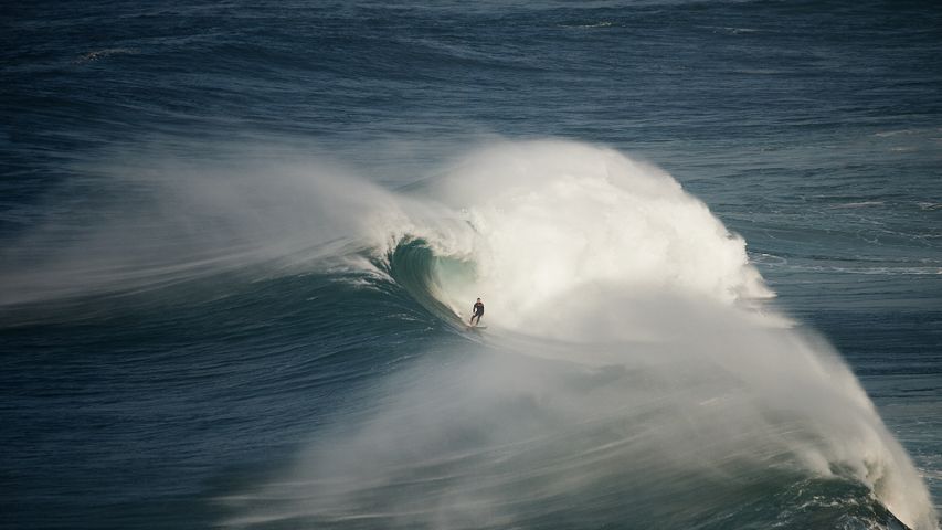 Surfista pegando onda em Nazaré, Portugal
