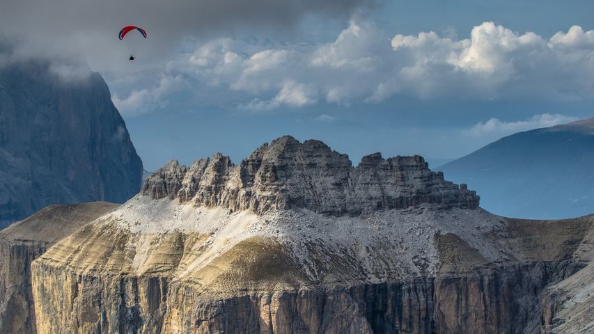 Parapendio che sorvola le Dolomiti, visto dal Sass Pordoi