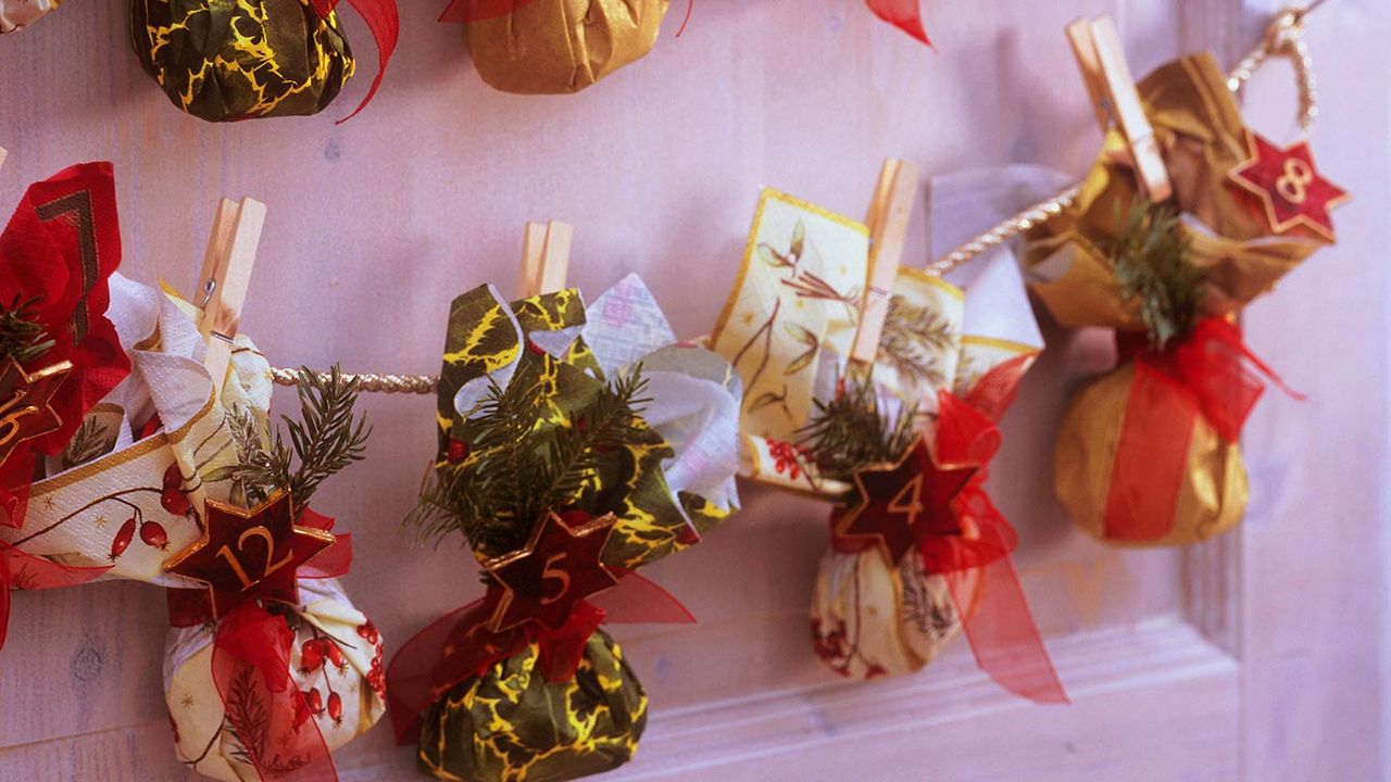Adventskalender mit kleinen, aus Servietten gefalteten Säckchen