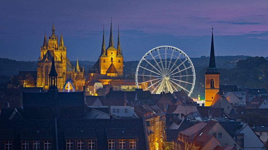 View of the Ferris wheel, Erfurt Cathedral, and St. Severus Church during Oktoberfest in Erfurt, Germany 
