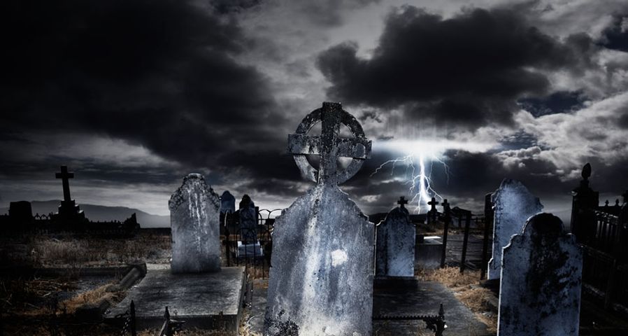 Dunkle Gewitterwolken und Blitze über einem Friedhof – Colin Anderson/Getty Images ©