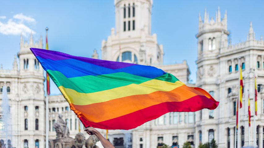 Brazos agitando la bandera LGBTQIA en la Plaza de Cibeles en Madrid, España