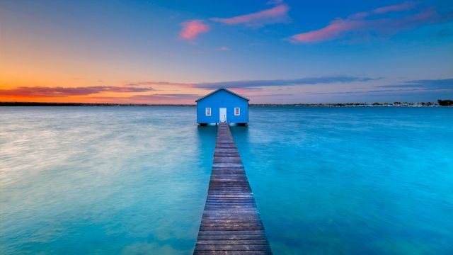 Sunrise over the Matilda Bay boathouse in the Swan River, Perth