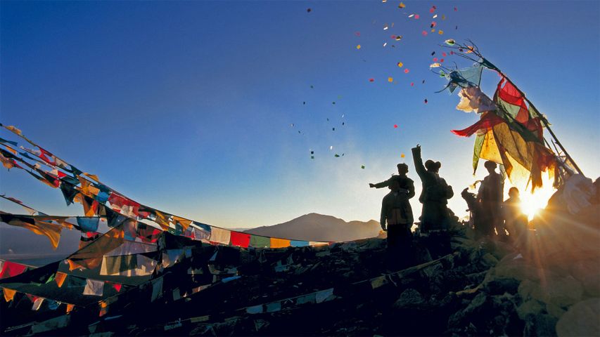 Pèlerins relâchant leurs chevaux du vent dans les airs, au-dessus du monastère de Ganden pour le Nouvel An Tibétain en Chine