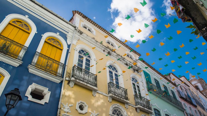 Rua em Salvador decorada com bandeiras coloridas entre prédios