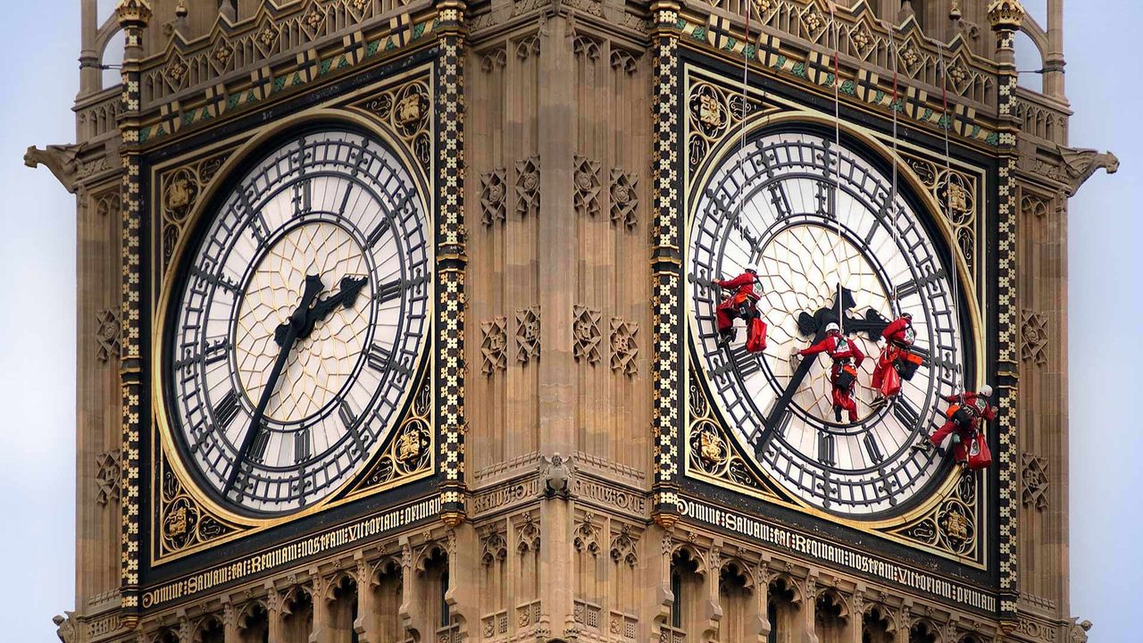 Workers cleaning the clock face of Big Ben in London, England
