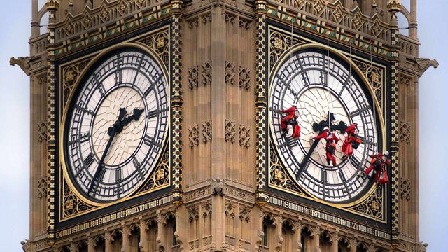 Workers cleaning the clock face of Big Ben, London