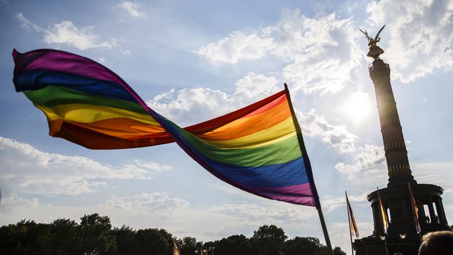Ein Teilnehmer schwenkt die Regenbogen-Flagge auf dem 40. Christopher Street Day vor der Siegessäule am 28. Juli 2018 in Berlin, Deutschland