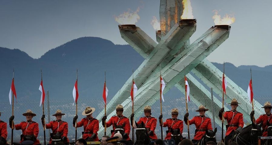 Canadian mounties parade with their horses in front of the Olympic flame in Vancouver on February 23, 2010 on the sidelines of the Vancouver Winter Olympics.