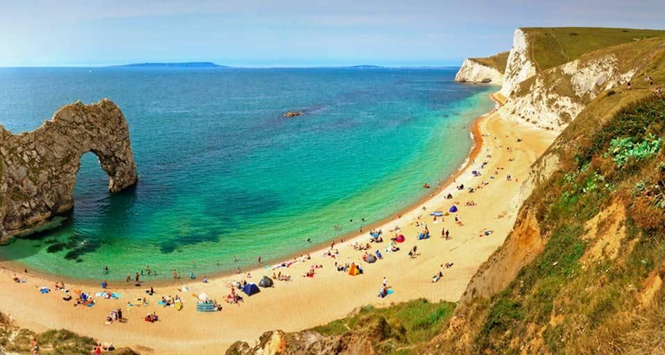 People enjoying the seaside at Durdle Door near Lulworth along the Jurassic Coast, Dorset, England