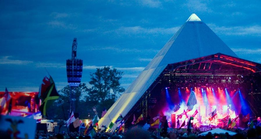 The Pyramid stage, all lit up at dusk, during a performance at the 2007 Glastonbury Festival in Somerset, UK --