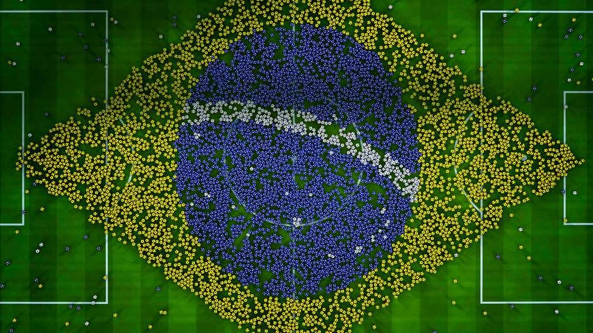 Balls on a football pitch forming a giant flag of Brazil