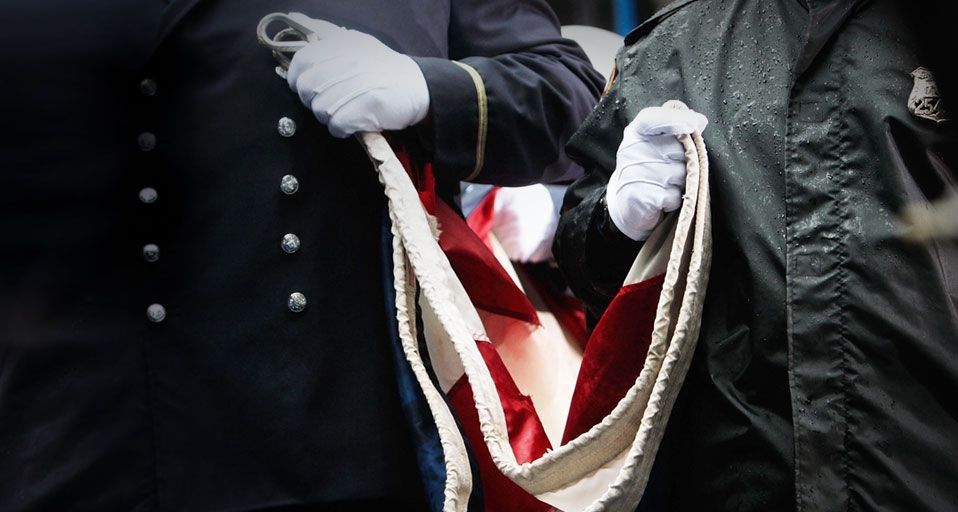 Firefighters hold a U.S. flag as they gather to pay their respects at Ground Zero during a 9/11 memorial ceremony on September 11, 2009, in New York City