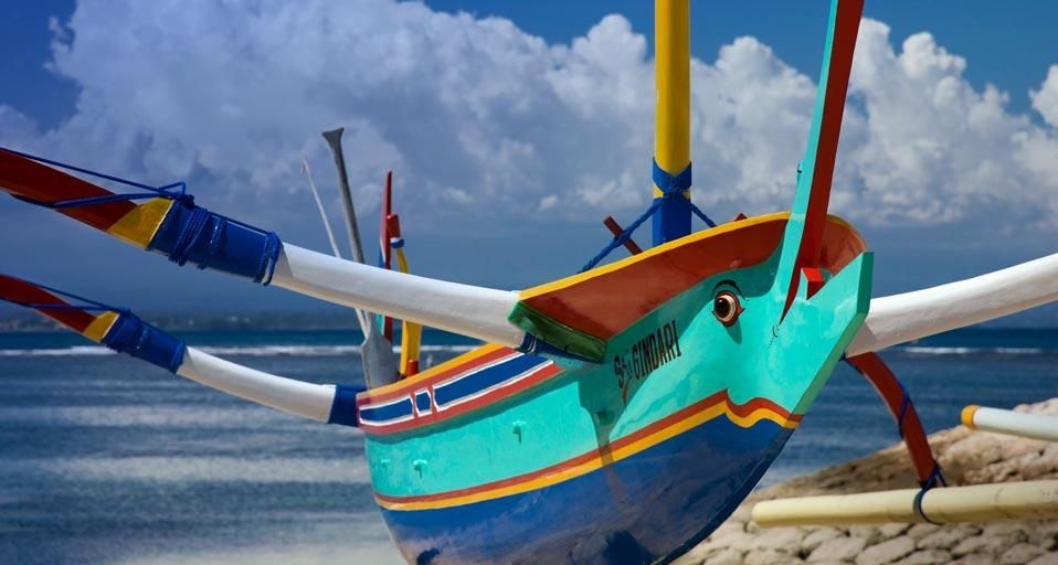 Traditional fishing craft drawn up on the sandy beach of Denpasar, Indonesia