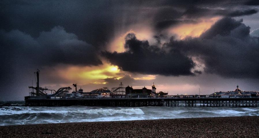A sunset and ominous moody sky over Brighton's Palace Pier