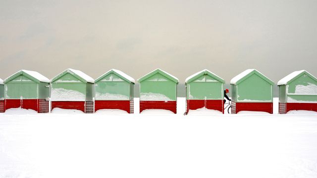 Beach huts covered in snow in Brighton and Hove, England