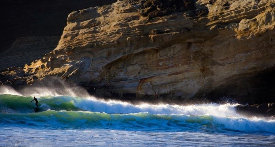 Surfeur ayant pris une vague près de Pacific City, Oregon, États-Unis